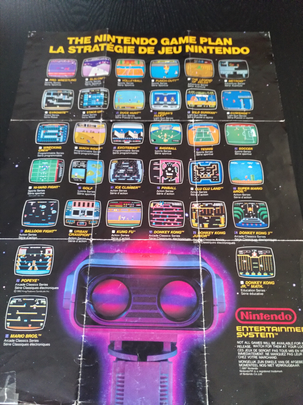 Poster officiel promotionnel listant des jeux NES. Sont cochés : Duck Hunt, Hogan's Alley, Wild Gunman, Excitebike, Baseball, Tennis, Soccer, Golf, Ice Climber, Pinball, Super Mario Bros., Balloon Fight, Donkey Kong, Donkey Kong Junior, Donkey Kong 3, Popeye, Mario Bros. ; Ne sont pas cochés : Pro Wrestling, Slalom, Volleyball, Punch-Out!!, The Legend of Zelda, Metroid, Gyromite, Stack-Up, Gumshoe, Wrecking Crew, Mach Rider, 10-Yard Fight, Clu Clu Land, Urban Champion, Kung Fu, Donkey Kong Junior Math